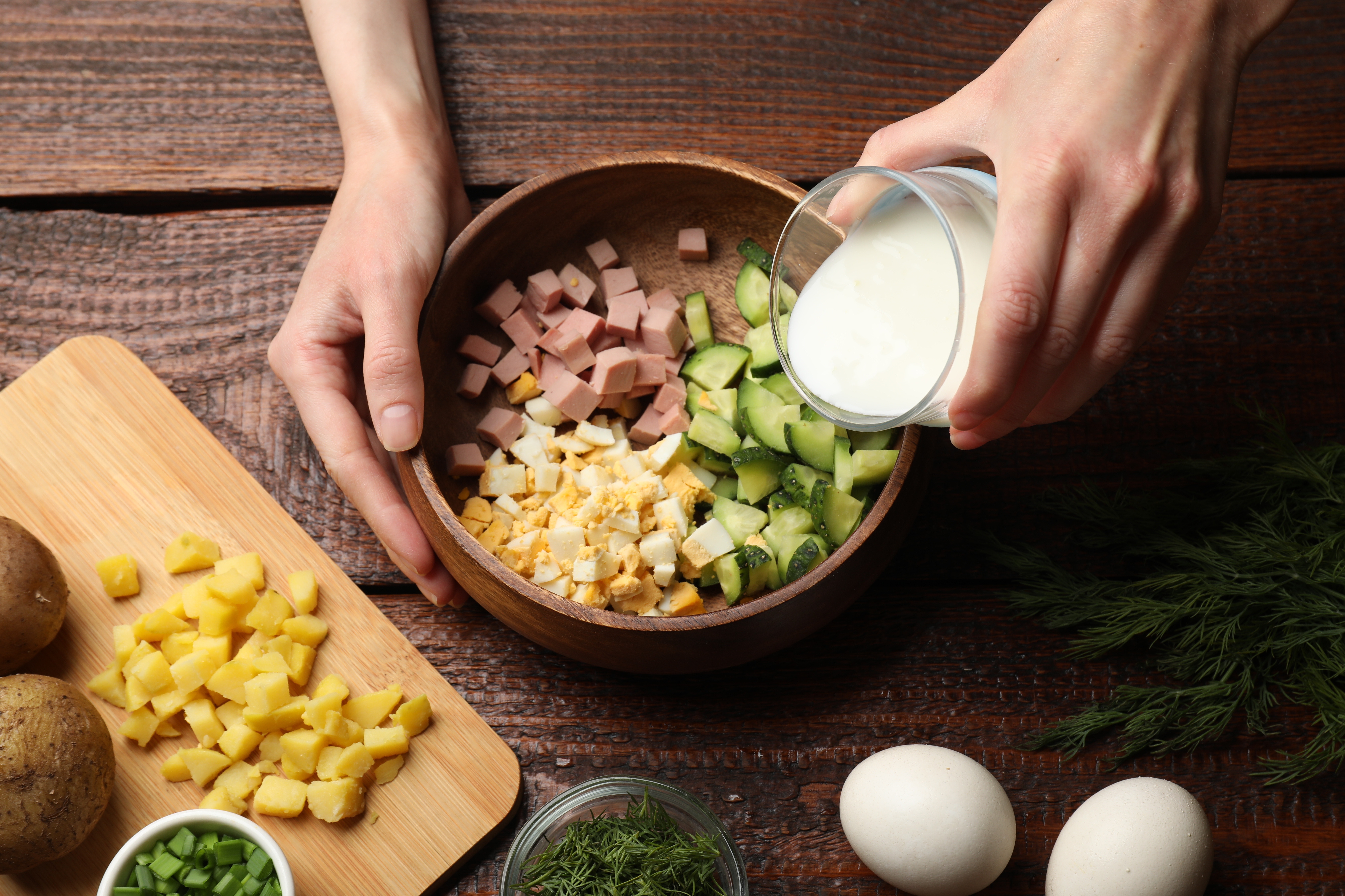 Adding kefir to the container with other ingredients.